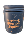Vela aromática gris con texto dorado Cumpliendo Sueños Juntos
