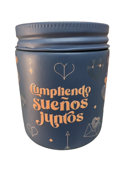 Vela aromática gris con texto dorado Cumpliendo Sueños Juntos