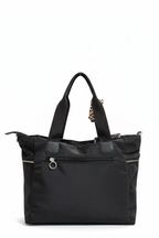 Detalle de la etiqueta leopardo y cremalleras del shopper negro