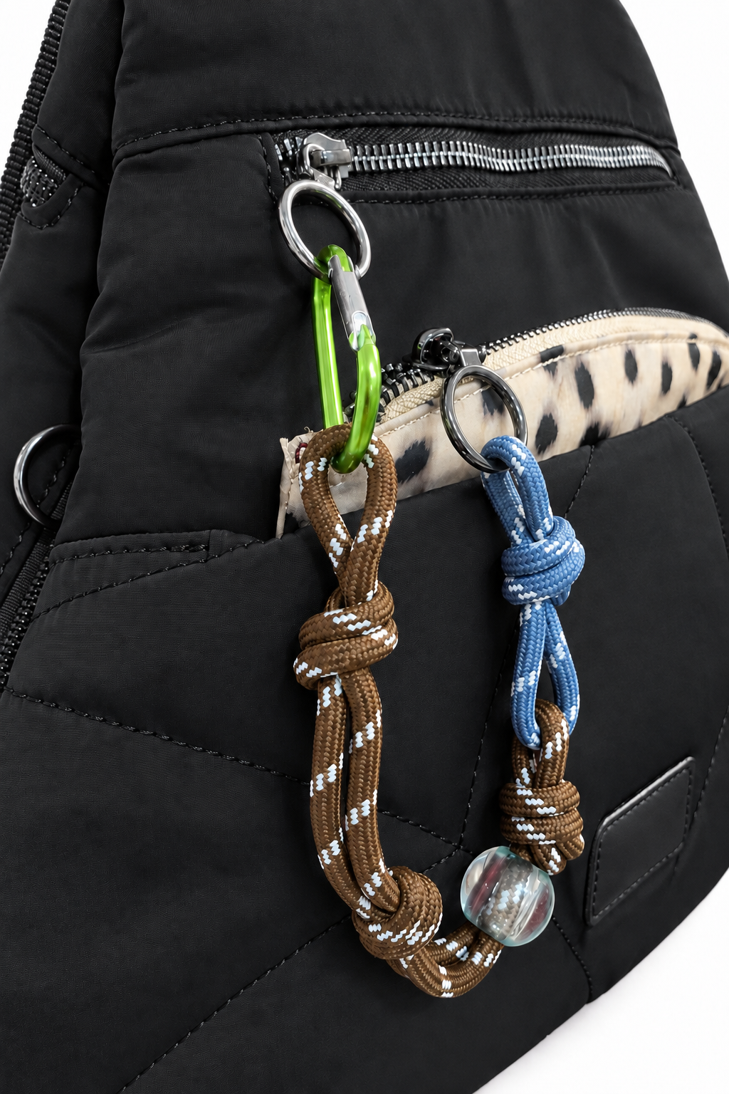 Detalle de mochila negra con bolsillo delantero y adornos