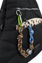 Detalle de mochila negra con bolsillo delantero y adornos