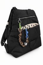 Mochila negra acolchada con bolsillos y adornos, vista frontal